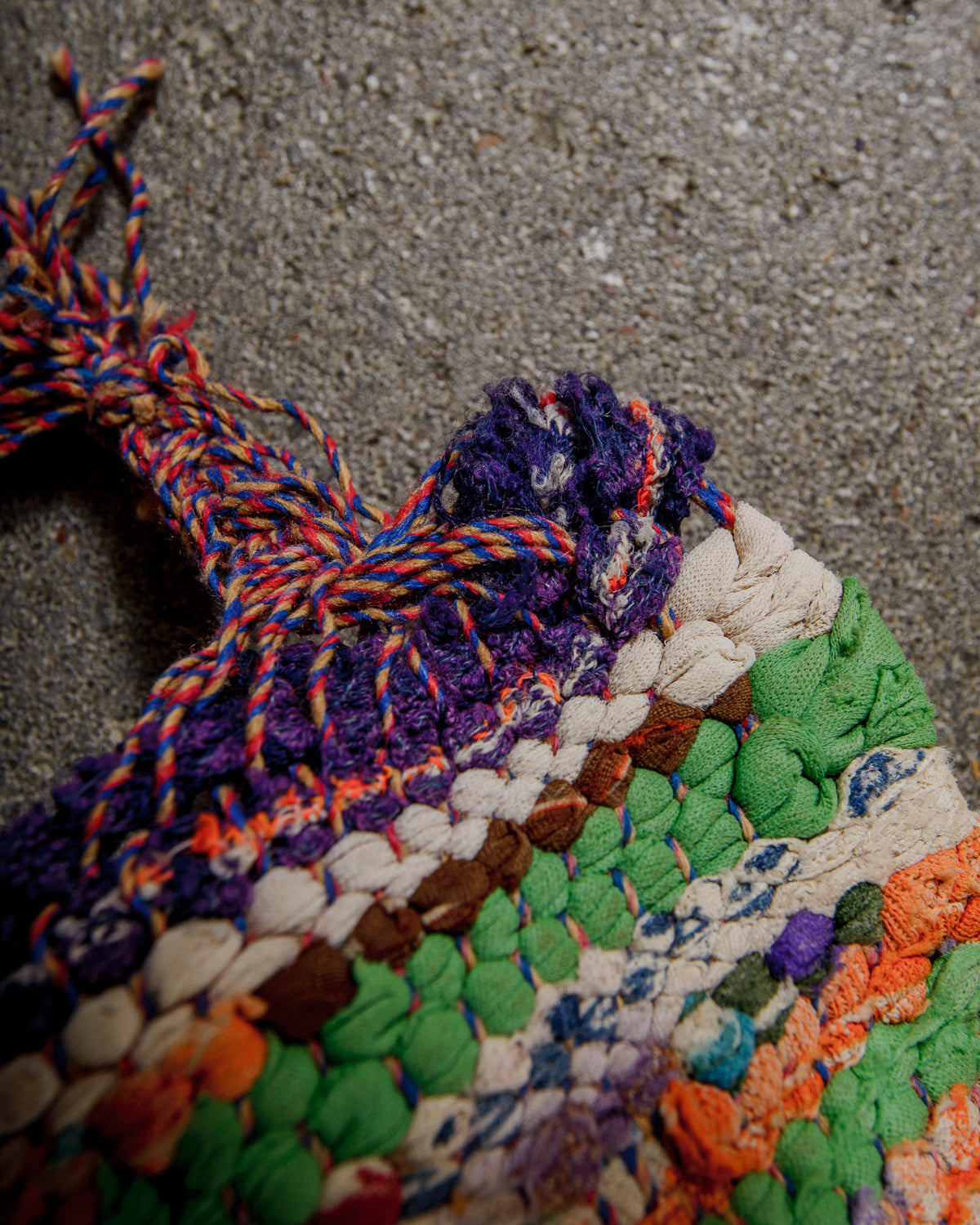 Multicoloured braided edge of a rug with a textured surface.